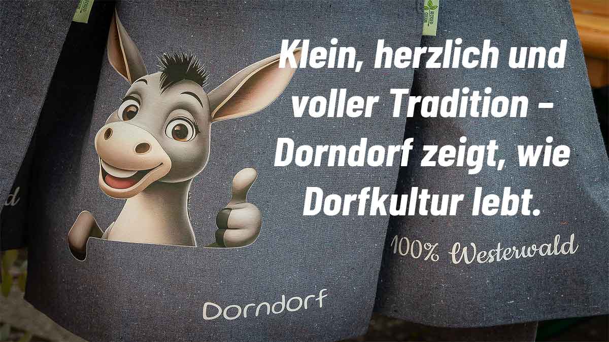 Illustration eines fröhlichen Esels mit erhobenem Daumen auf einem Stoffbeutel, daneben der Schriftzug: ‚Klein, herzlich und voller Tradition – Dorndorf zeigt, wie Dorfkultur lebt.‘