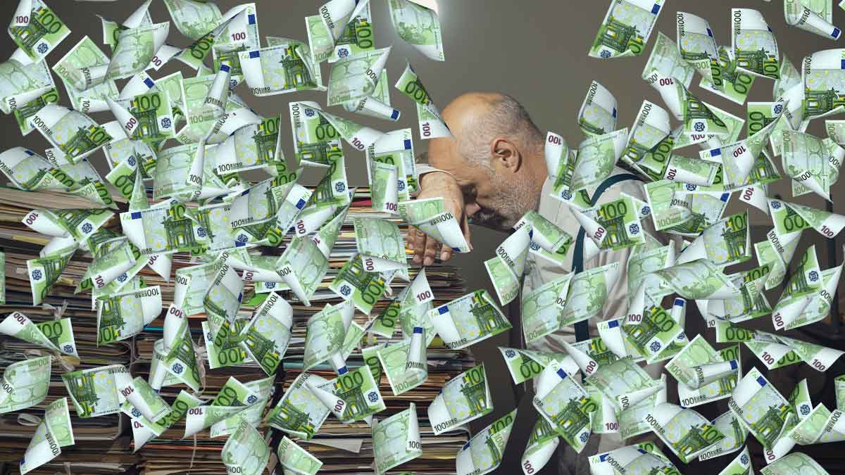 Ein Mann lehnt erschöpft auf einem hohen Stapel Aktenordner, während hunderte Euro-Scheine durch die Luft wirbeln – Symbolbild für Bürokratie, die Millionen-Fördergelder auffrisst.